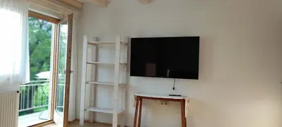 a living room with a flat screen tv on a wall at Green Garden Apartment in Bled