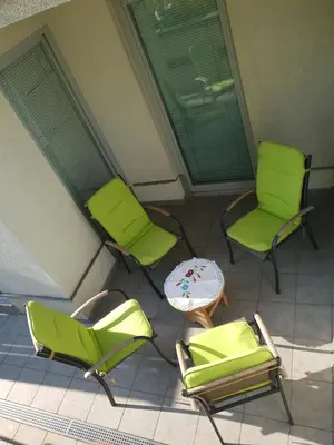 three green chairs and a table on a balcony at Victoria Apartment in Ljubljana