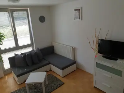 a living room with a couch and a tv at Victoria Apartment in Ljubljana