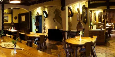 a restaurant with wooden tables and chairs in a room at Natura Amon in Podčetrtek