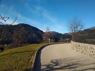 a winding road with a fence and mountains in the background at Apartment Jorsi with Mountain View in Zreče
