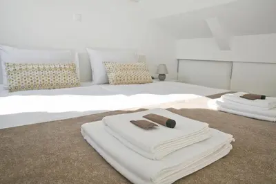 a bedroom with two white towels on a bed at Apartments Hiša Pod Gradom in Ljubljana
