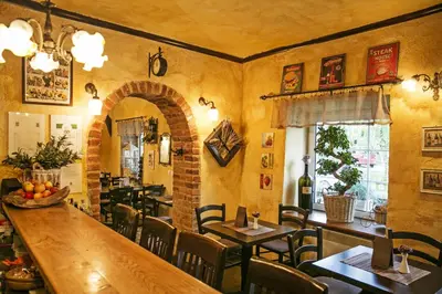 a restaurant with a large wooden table and chairs at Apartments Hiša Pod Gradom in Ljubljana