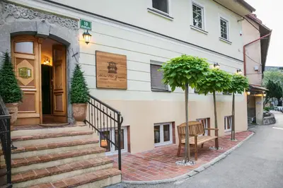 a building with stairs and a tree in front of it at Apartments Hiša Pod Gradom in Ljubljana