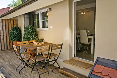 a patio with a table and chairs on a deck at Apartments Hiša Pod Gradom in Ljubljana