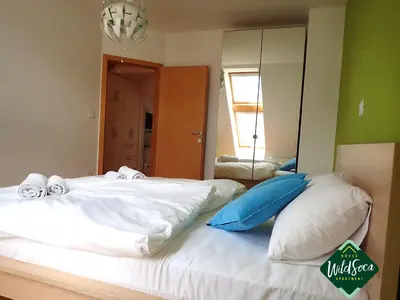 a bedroom with a large bed with a mirror at Wild Soca House Apartment No.5 in Bovec