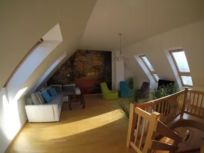 a living room with a white couch in a attic at Wild Soca House Apartment No.5 in Bovec
