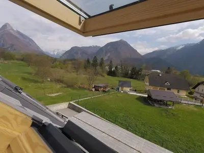 a view from a window of a field and mountains at Wild Soca House Apartment No.5 in Bovec