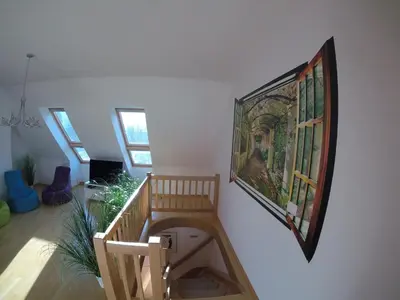 a room with a painting on the wall and a staircase at Wild Soca House Apartment No.5 in Bovec
