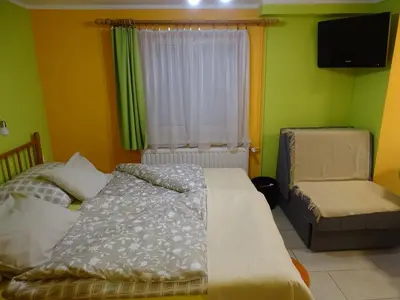 a bedroom with a bed and a chair and a window at Sobe- Rooms - Apartments - Free parking! in Maribor
