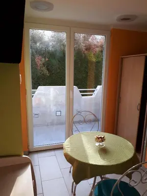 a table and chairs in a room with a sliding glass door at Sobe- Rooms - Apartments - Free parking! in Maribor