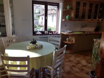 a kitchen with a table with chairs and a window at Apartment Slavi in Vipava