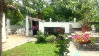 a garden in front of a house with a fireplace at Apartment Slavi in Vipava