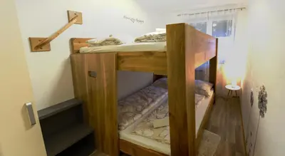 a wooden bunk bed in a room at Apartments Laznica in Cerkno