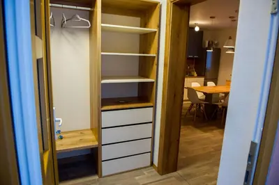 a closet with white shelves and a table at Apartments Laznica in Cerkno