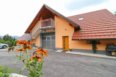 a building with a balcony and a parking lot at Apartments Laznica in Cerkno