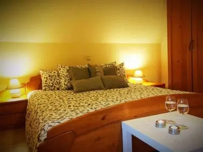 a bedroom with a bed with two glasses of wine at gostišče uh- planica in Rateče