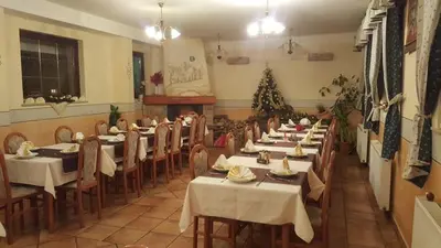 a restaurant with tables and chairs and a christmas tree at gostišče uh- planica in Rateče