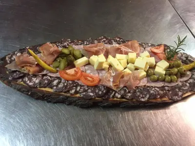 a sandwich with meat cheese and vegetables on a table at gostišče uh- planica in Rateče