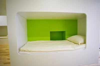 a room with a bed with a green wall at Youth Hostel Ajdovscina in Ajdovščina