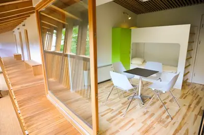 a dining room with a table and white chairs at Youth Hostel Ajdovscina in Ajdovščina
