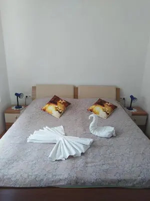 a bed with a swan and two towels on it at Apartma Viktorija in Kranjska Gora