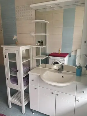 a bathroom with a sink and a microwave at Apartma Viktorija in Kranjska Gora