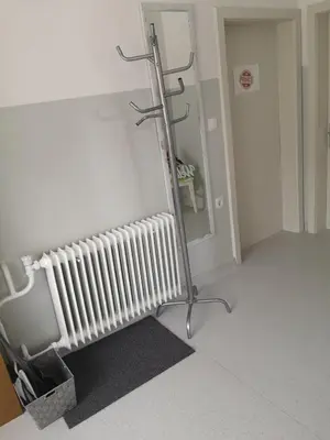 a hospital room with a radiator and a mirror at Apartma Viktorija in Kranjska Gora