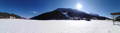a snow covered field with a mountain in the background at Apartma Viktorija in Kranjska Gora