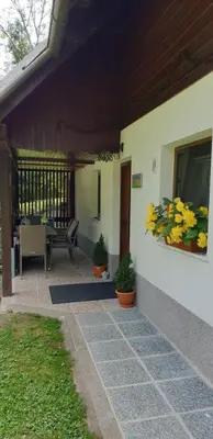 a porch of a house with a bench and flowers at Apartment Sonce in Bohinj