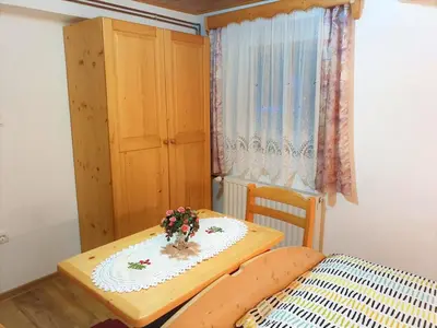 a small room with a table and a bed at Apartment Sonce in Bohinj