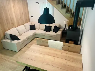 a living room with a white couch and a staircase at Chalet Jasmin in Bohinj
