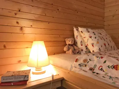 a teddy bear sitting on a bed next to a lamp at Chalet Jasmin in Bohinj