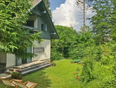 a backyard of a house with a yard with chairs at Chalet Jasmin in Bohinj