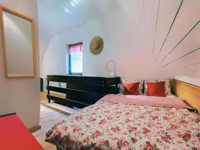 a bedroom with a large bed with red pillows at Chalet Jasmin in Bohinj