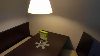 a table with a lamp and a green box on it at Apartma Kurji vrh - Chicken top in Kranjska Gora