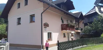 a little girl standing in front of a building at apartma Albina in Kranjska Gora