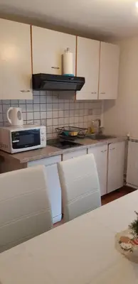 a kitchen with white cabinets and a microwave at apartma Albina in Kranjska Gora