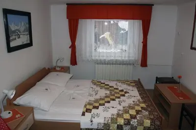 a bedroom with a bed and a window with red curtains at apartma Albina in Kranjska Gora