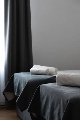 two towels sitting on two beds in a room at Hotel Tabor in Sežana