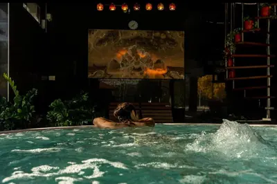 a person in a swimming pool with a fireplace at Hotel Strk in Murska Sobota