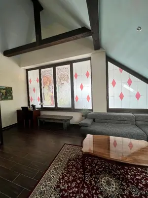 a living room with a couch and some windows at Hotel Strk in Murska Sobota