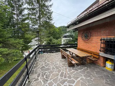 a wooden bench sitting on the side of a building at MaxDan Lodge in Kranjska Gora