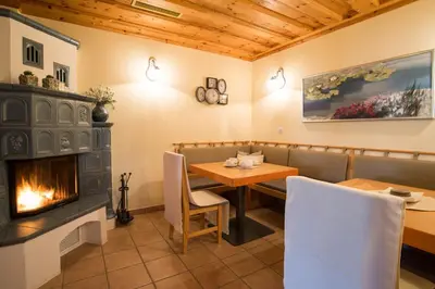 a dining room with a fireplace and a table and chairs at Penzion Mayer in Bled