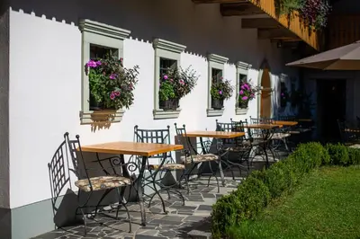 a group of tables and chairs outside of a building at Penzion Mayer in Bled