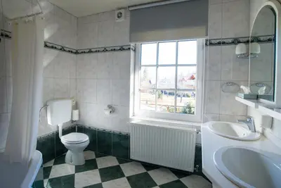 a bathroom with a toilet and a sink and a window at Penzion Mayer in Bled