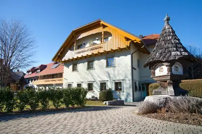 a building with a clock tower in front of it at Penzion Mayer in Bled
