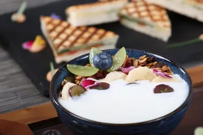 a bowl of yogurt with fruit and nuts on top at Hotel Cubo in Ljubljana