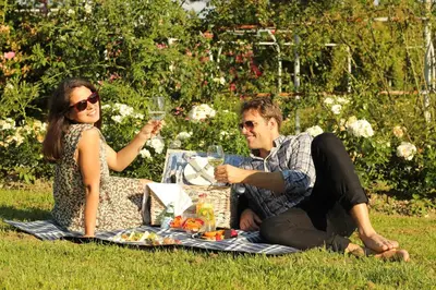 a man and a woman sitting on a picnic blanket at Hotel Cubo in Ljubljana