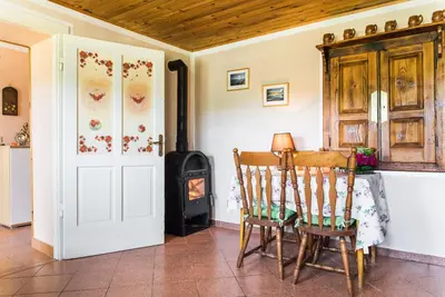 a room with a table and chairs and a stove at Počitniška hiša Pologar in Tolmin